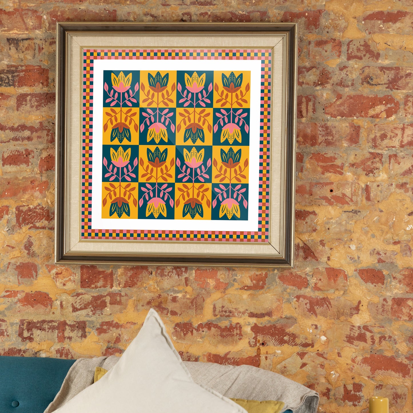 Framed colorful pattern on a brick wall with a blue sofa and yellow vase.