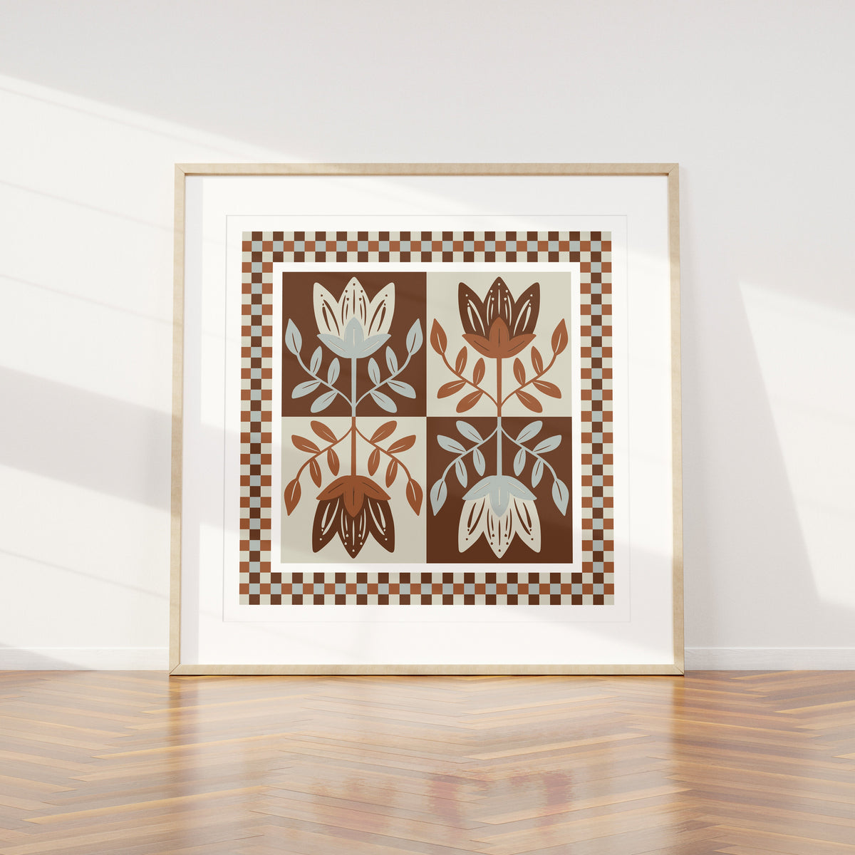 Framed artwork with mirrored folksy floral design on a white wall