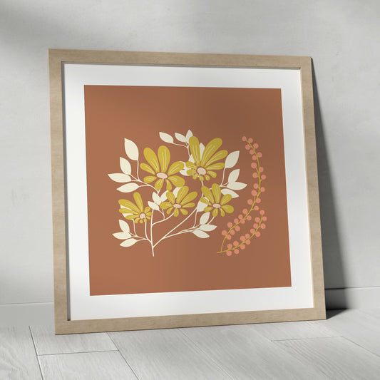 Framed artwork with floral design on a brown background, placed on a light wooden floor.