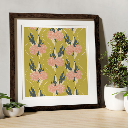 Framed floral artwork on a wooden table with plants
