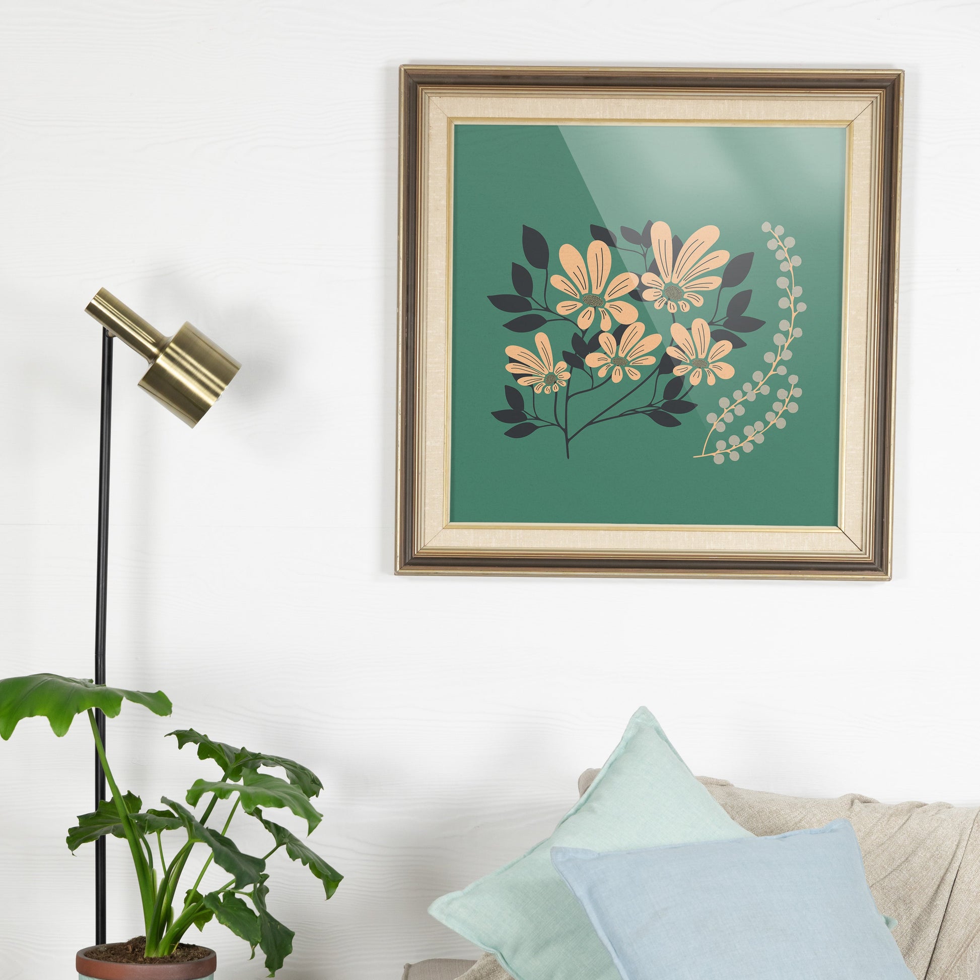 Living room with a sofa, plant, and framed artwork on the wall.