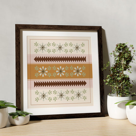 Framed artwork with geometric patterns on a wooden surface with plants